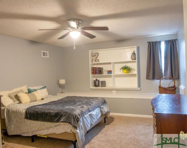 bedroom featuring ceiling fan, light colored carpet, and a textured ceiling