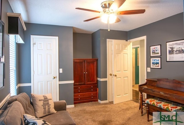 living area with light colored carpet and ceiling fan