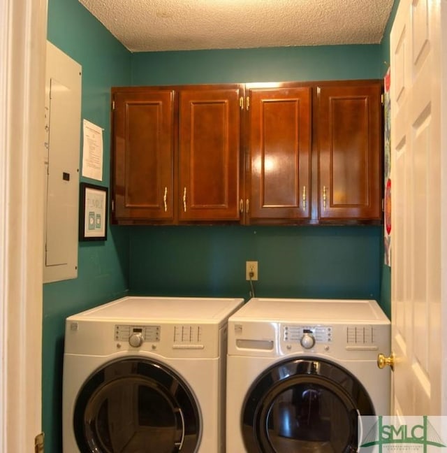 laundry area with cabinets, electric panel, washer and dryer, and a textured ceiling