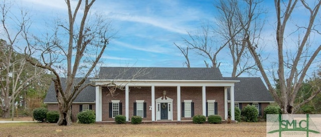 greek revival inspired property featuring a front lawn