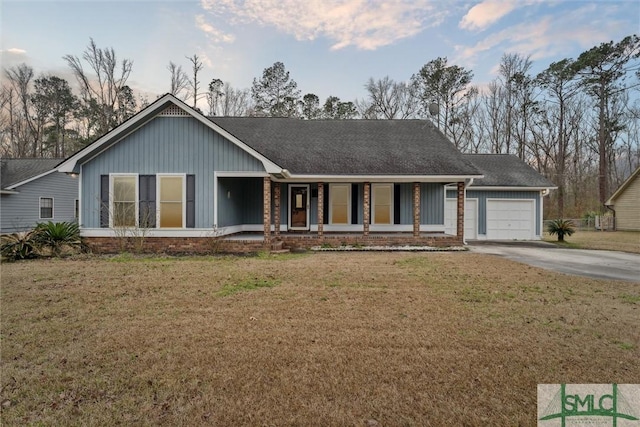 single story home featuring a garage, a porch, and a front lawn