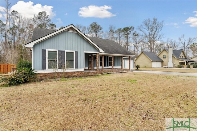 view of front of home featuring a garage, a front yard, and a porch