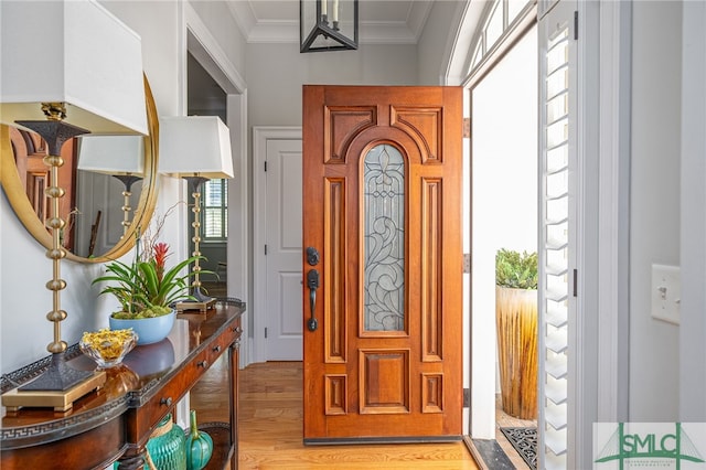 entryway with crown molding and light hardwood / wood-style floors