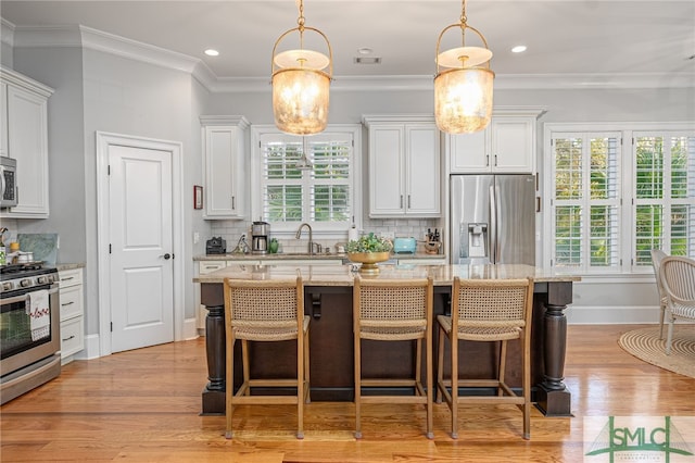 kitchen with white cabinetry, stainless steel appliances, and a kitchen island