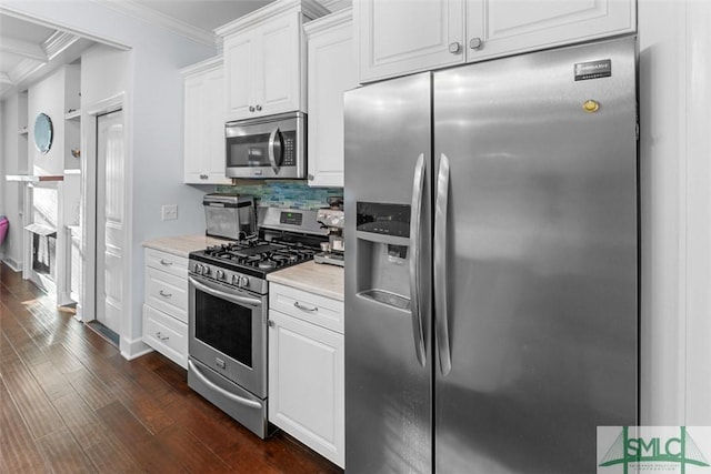 kitchen featuring white cabinetry, crown molding, tasteful backsplash, dark hardwood / wood-style floors, and stainless steel appliances