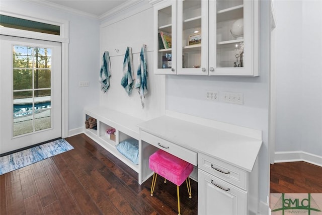 mudroom featuring ornamental molding, built in desk, and dark hardwood / wood-style flooring