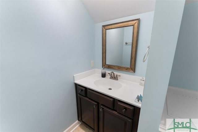 bathroom featuring vanity and lofted ceiling