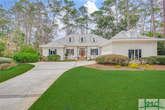 view of front of house featuring a garage, french doors, and a front lawn