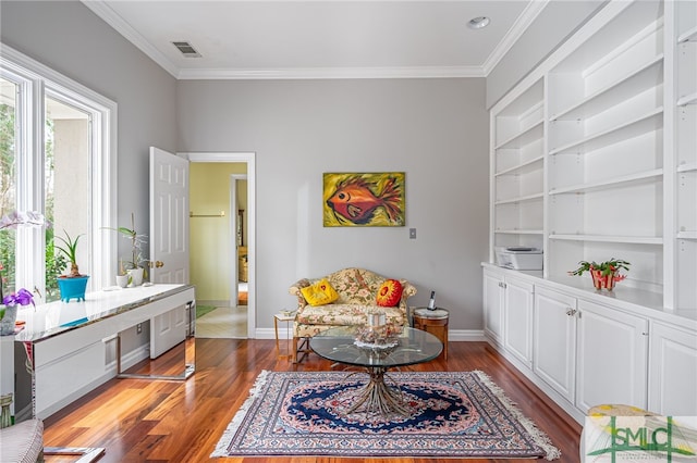 living area featuring crown molding, hardwood / wood-style floors, and built in shelves