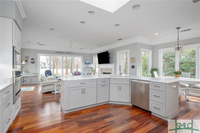 kitchen with stainless steel appliances, crown molding, a center island, and sink