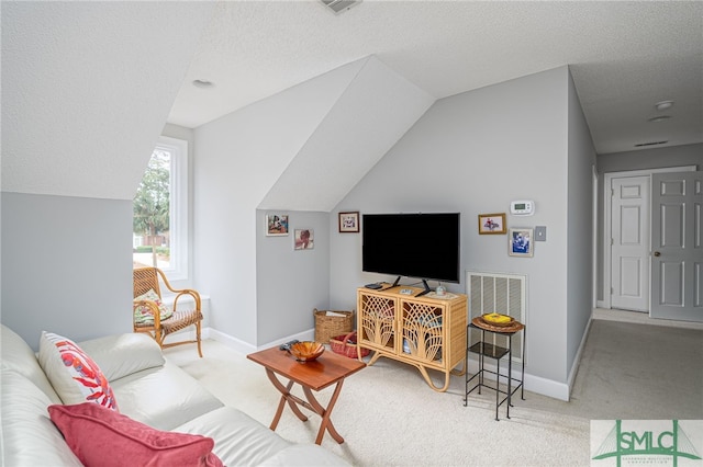 living room with lofted ceiling, light colored carpet, and a textured ceiling