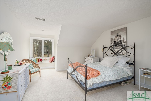 carpeted bedroom with lofted ceiling and a textured ceiling