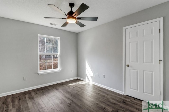 unfurnished room featuring dark hardwood / wood-style floors, a textured ceiling, and ceiling fan