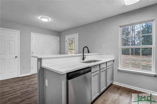 kitchen featuring dishwasher, sink, gray cabinetry, and dark hardwood / wood-style flooring