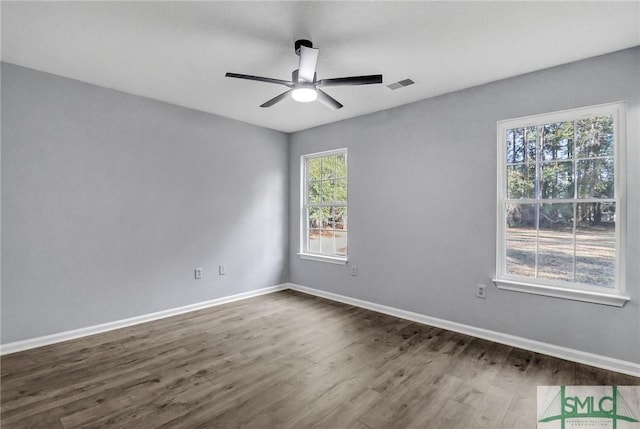 spare room with dark wood-type flooring and ceiling fan