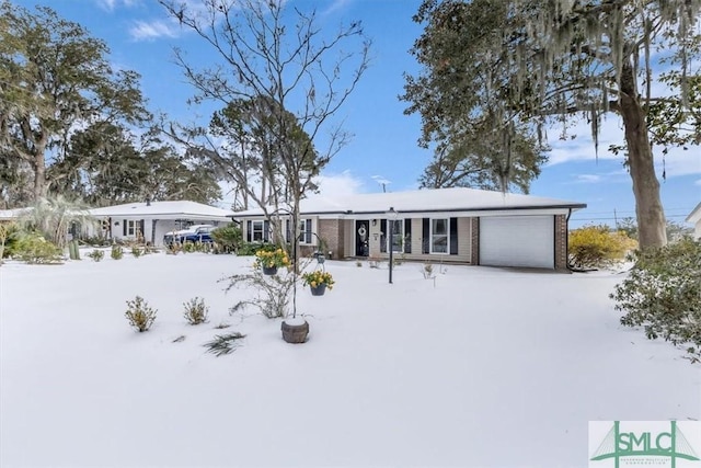 snow covered house featuring a garage