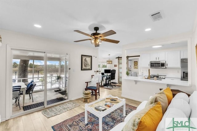 living room featuring light hardwood / wood-style floors and ceiling fan