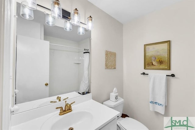 bathroom featuring vanity, toilet, and a shower