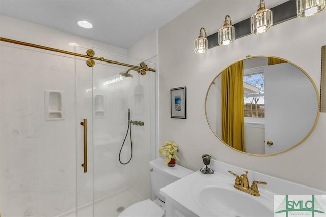 bathroom with vanity, a shower with shower door, and toilet