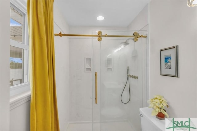 bathroom with toilet and an enclosed shower