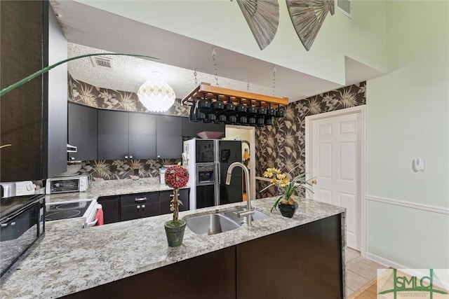 kitchen with sink, light stone counters, black refrigerator with ice dispenser, light tile patterned floors, and electric stove