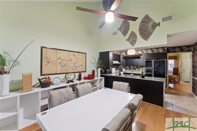 dining room featuring ceiling fan, sink, and light hardwood / wood-style flooring