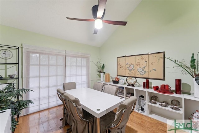 dining area with ceiling fan, lofted ceiling, and light wood-type flooring