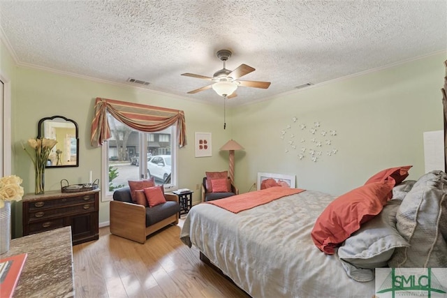 bedroom with crown molding, ceiling fan, a textured ceiling, and light wood-type flooring