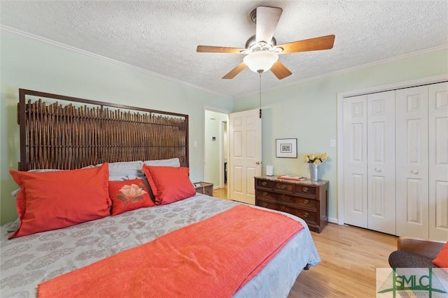 bedroom featuring light hardwood / wood-style flooring, ceiling fan, ornamental molding, a textured ceiling, and a closet