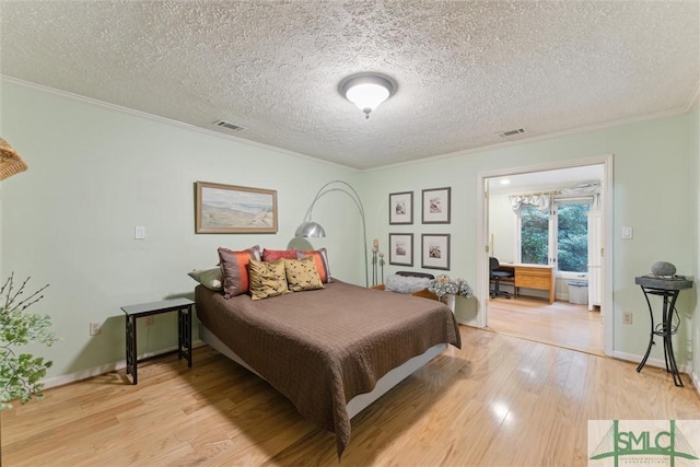 bedroom with hardwood / wood-style flooring, crown molding, and a textured ceiling