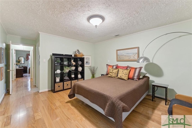 bedroom with ornamental molding, hardwood / wood-style floors, and a textured ceiling