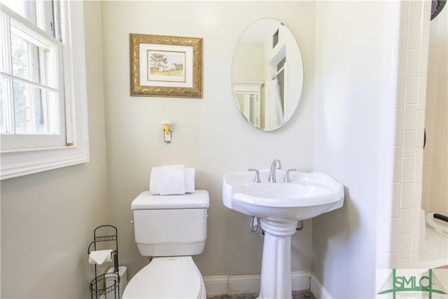 bathroom with toilet and curtained shower