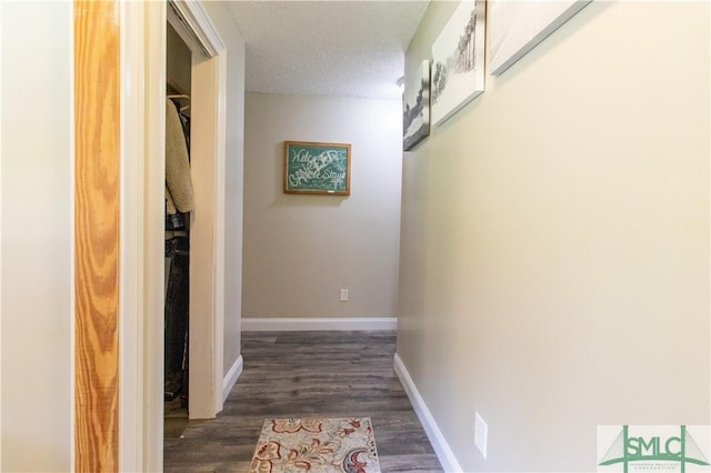 hallway featuring dark hardwood / wood-style flooring and a textured ceiling