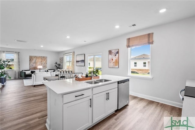 kitchen featuring sink, dishwasher, an island with sink, light hardwood / wood-style floors, and white cabinets