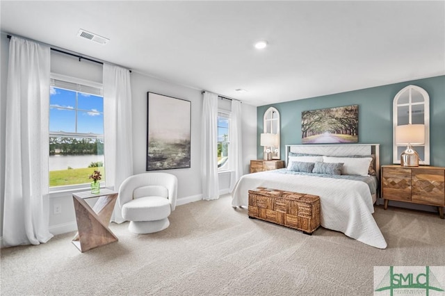 carpeted bedroom with a water view