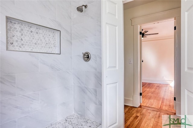 bathroom featuring a tile shower and wood-type flooring