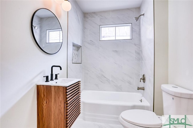 full bathroom with vanity, tiled shower / bath, and toilet