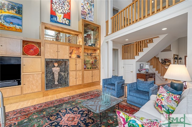 living room featuring hardwood / wood-style floors and a towering ceiling