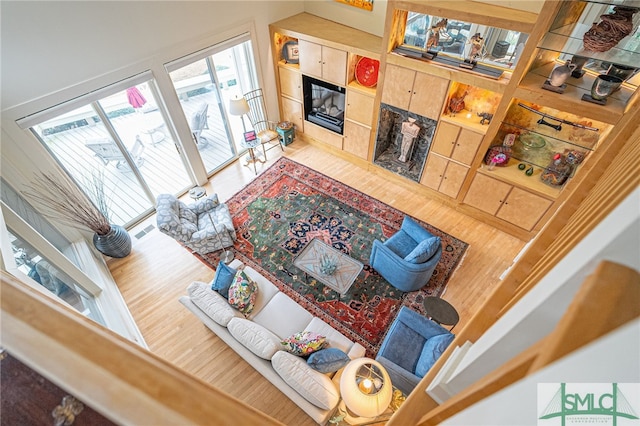 living room with a tiled fireplace and hardwood / wood-style floors