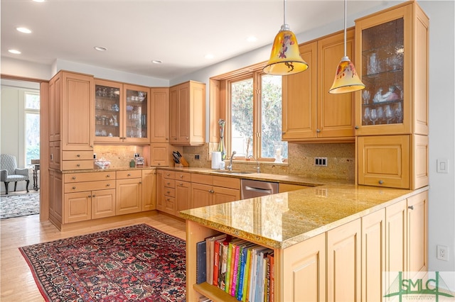 kitchen with a healthy amount of sunlight, hanging light fixtures, sink, and dishwasher