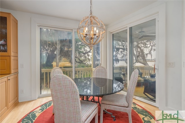 dining area with plenty of natural light, a chandelier, and light wood-type flooring