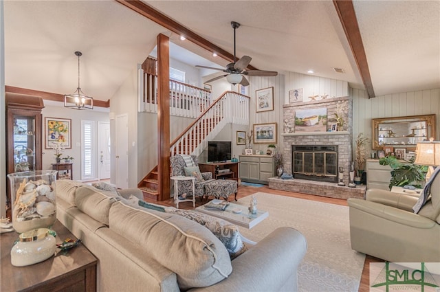 living room featuring beamed ceiling, high vaulted ceiling, hardwood / wood-style flooring, and a fireplace