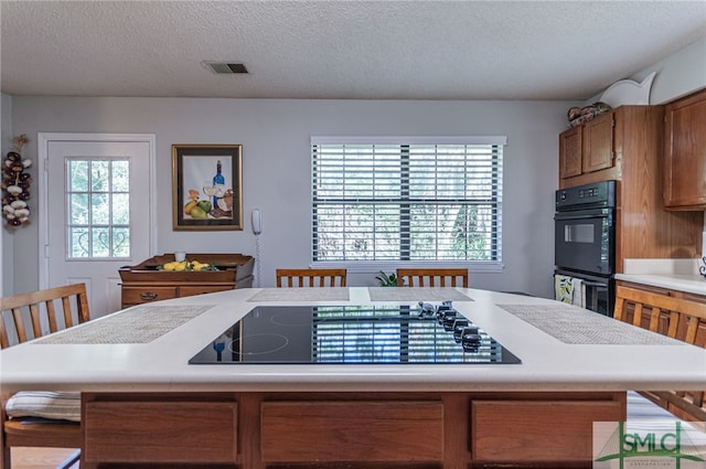 kitchen featuring a textured ceiling and black appliances