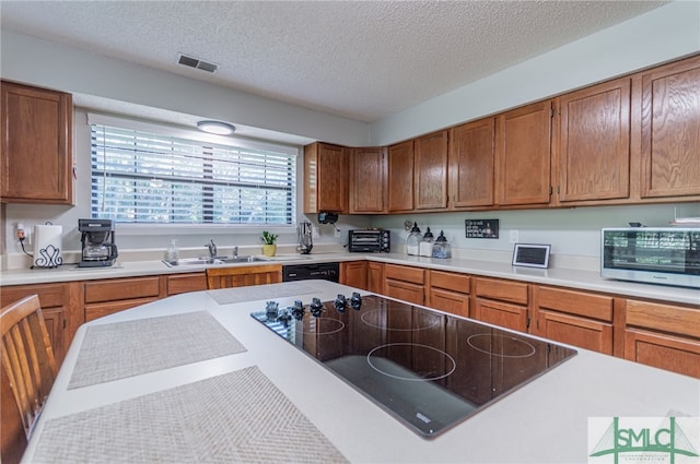 kitchen featuring sink, black appliances, and a textured ceiling