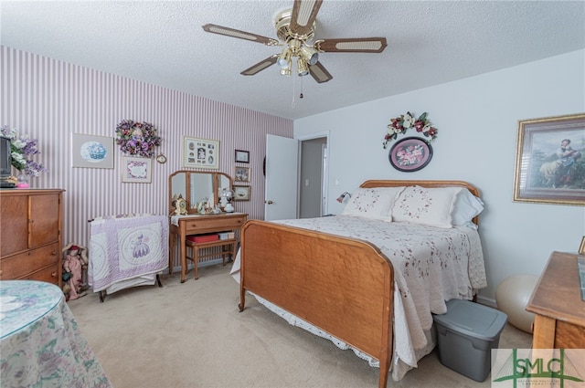 bedroom featuring ceiling fan, light colored carpet, and a textured ceiling