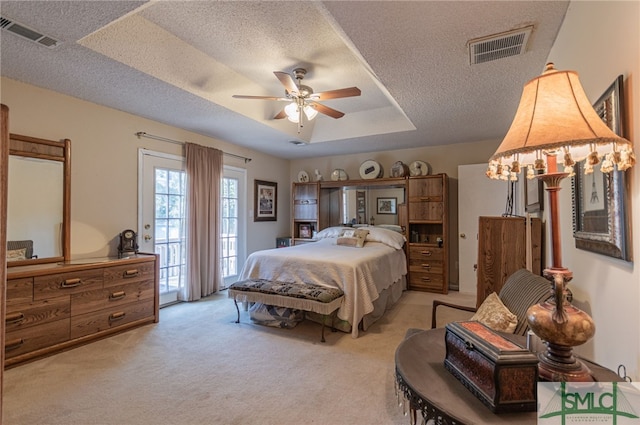 carpeted bedroom featuring ceiling fan, access to outside, a raised ceiling, and a textured ceiling