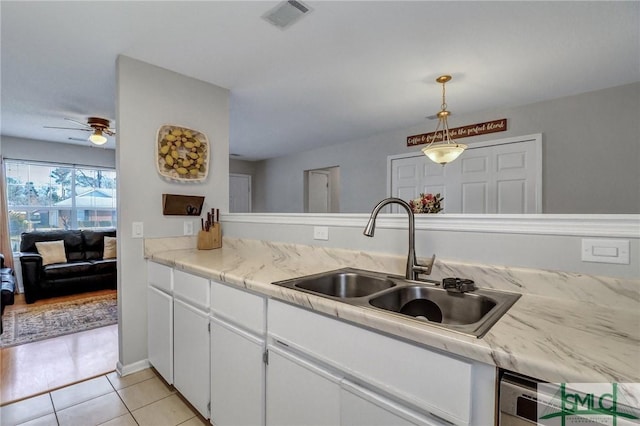 kitchen featuring decorative light fixtures, white cabinetry, sink, light tile patterned floors, and ceiling fan