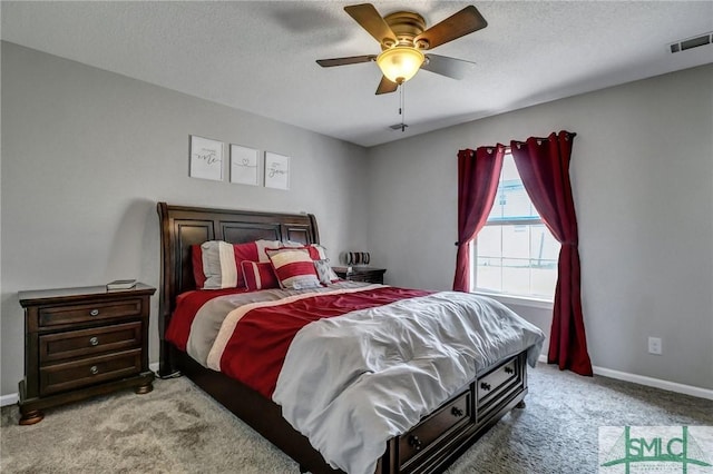 carpeted bedroom featuring ceiling fan and a textured ceiling