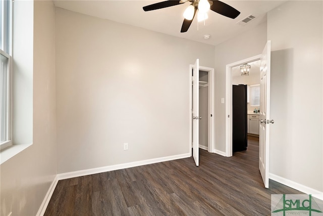 unfurnished bedroom with ceiling fan and dark hardwood / wood-style floors