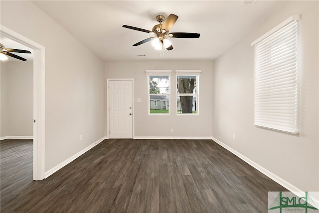 spare room with dark hardwood / wood-style flooring and ceiling fan